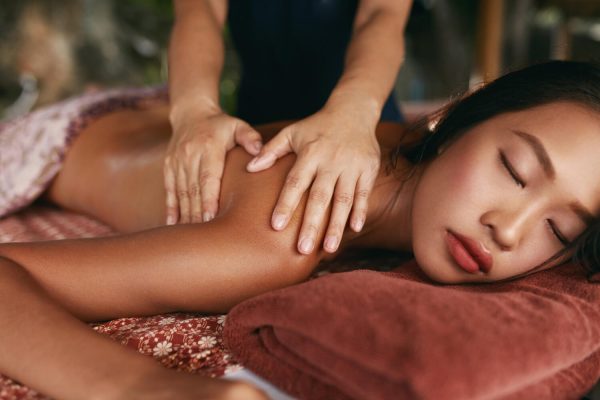 Massage traditionnel thaï pratiqué sur une femme détendue